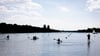 Menschen sind am Vatertag bei sonnigem Wetter mit Kanu, Stand-up-Paddle-Board und Booten auf dem Maschsee unterwegs.