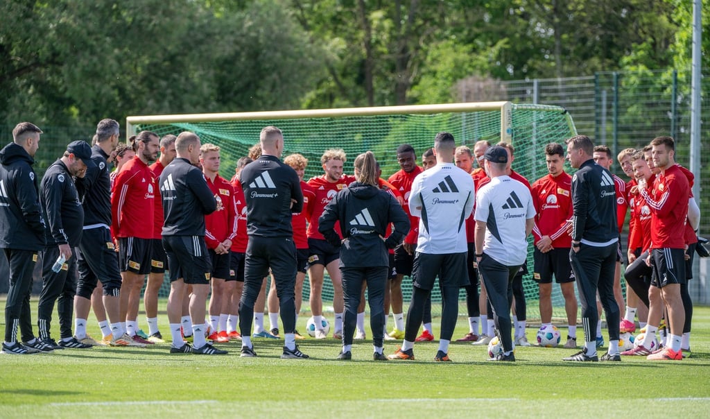 Trainer Marco Grote (6. v.r) spricht zur Mannschaft.