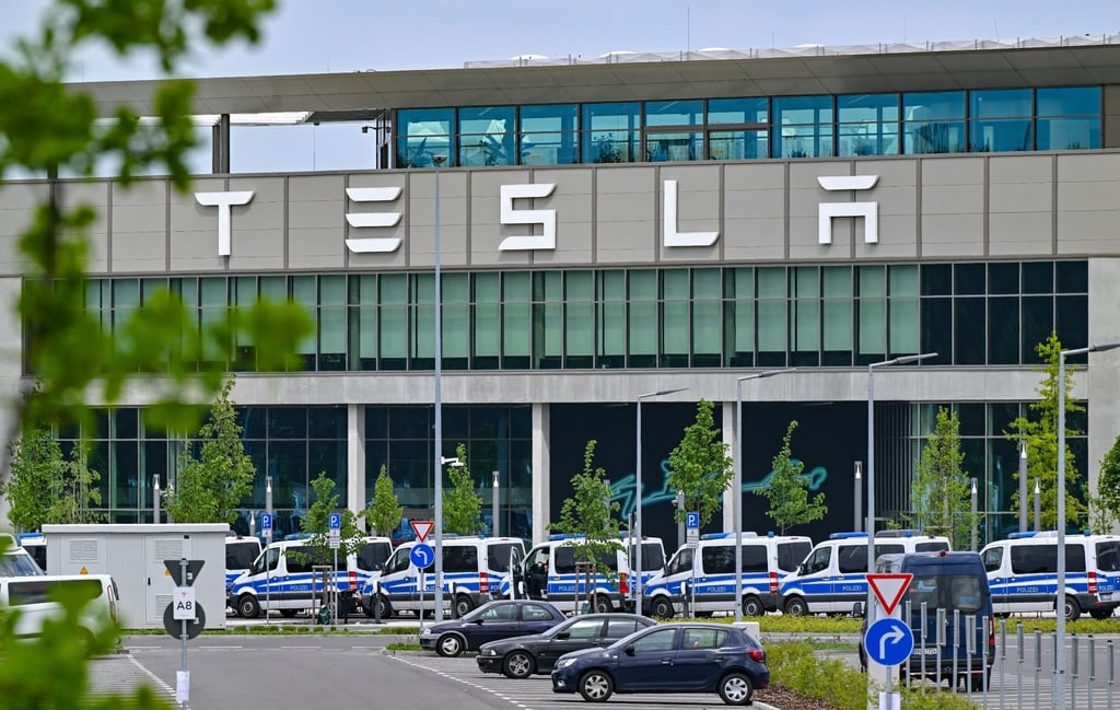 Mehrere Fahrzeuge der Polizei stehen zur Sicherheit vor dem Haupteingang zum Werk von Tesla.