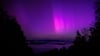 Polarlichter (Aurora borealis) leuchten am nächtlichen Himmel über dem Kochelsee.