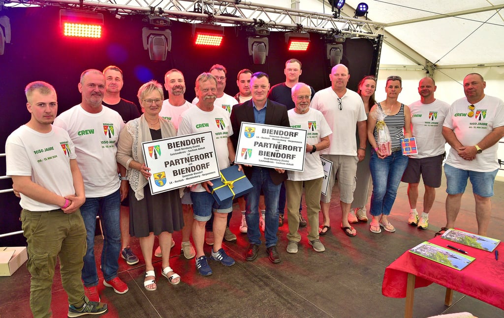 Nach der Unterzeichnung des Partnerschaftsvertrages präsentierten Mitglieder des Ortschaftsrates und des Gemeinderates der beiden Biendorfs gemeinsam mit Bernburgs Oberbürgermeisterin Silvia Ristow (4. von links) die Schilder, die an den Ortseingängen angebracht werden sollen.