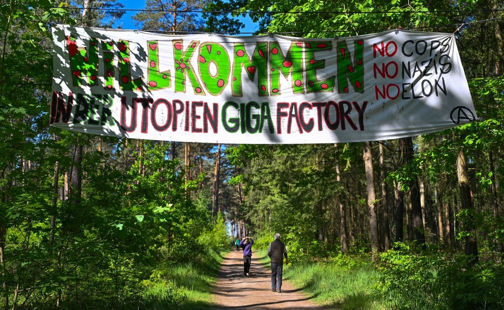Aktivisten der Initiative „Tesla stoppen“ haben in einem Wald nahe dem Werk der Tesla-Gigafactory Berlin-Brandenburg ein Transparent mit der Aufschrift „Willkommen in der Utopien Giga Factory No Cops, No Nazis, No Elon“ aufgehängt.