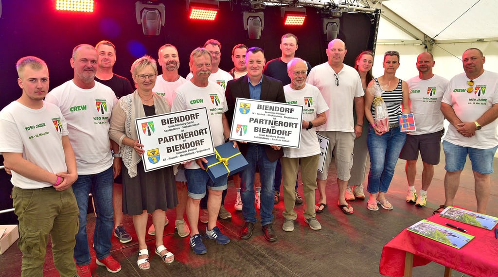 Nach der Unterzeichnung des Partnerschaftsvertrages präsentierten Mitglieder des Ortschaftsrates und des Gemeinderates der beiden Biendorfs gemeinsam mit Bernburgs Oberbürgermeisterin Silvia Ristow (4. von links) die Schilder, die an den Ortseingängen angebracht werden sollen.