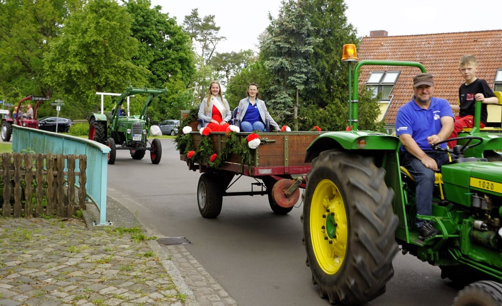 Sabrina (rechts) und Josefine lassen sich standesgemäß von Sven Grütter bei der Treckerparade durchs Dorf kutschieren.