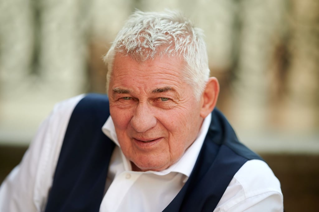 Der Schauspieler Heinz Hoenig sitzt bei einem Fototermin bei Dreharbeiten zur TVNOW Serie "Verbotene Liebe - Next Generation" auf einer Treppe.