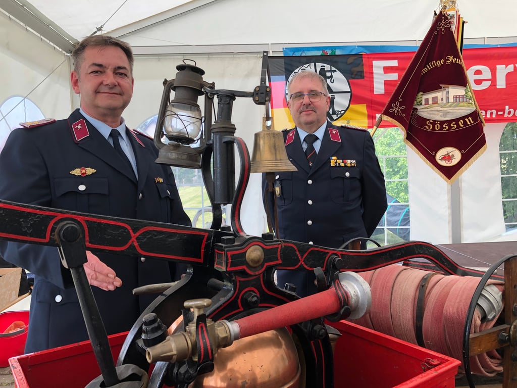 An einer Spritze aus em Jahr 1893: der Sössener Wehrleiter André Haushälter (li.) und Peter Reinhardt, Vorsitzender des Kreisfeuerwehrverbandes Weißenfels.