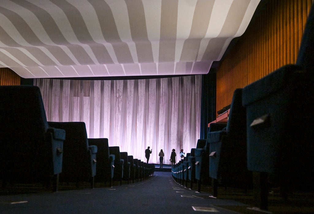 Bei einer Presseführung wird im Kino International der Zuschauerraum mit dem Vorhang vor der Kinoleinwand gezeigt.
