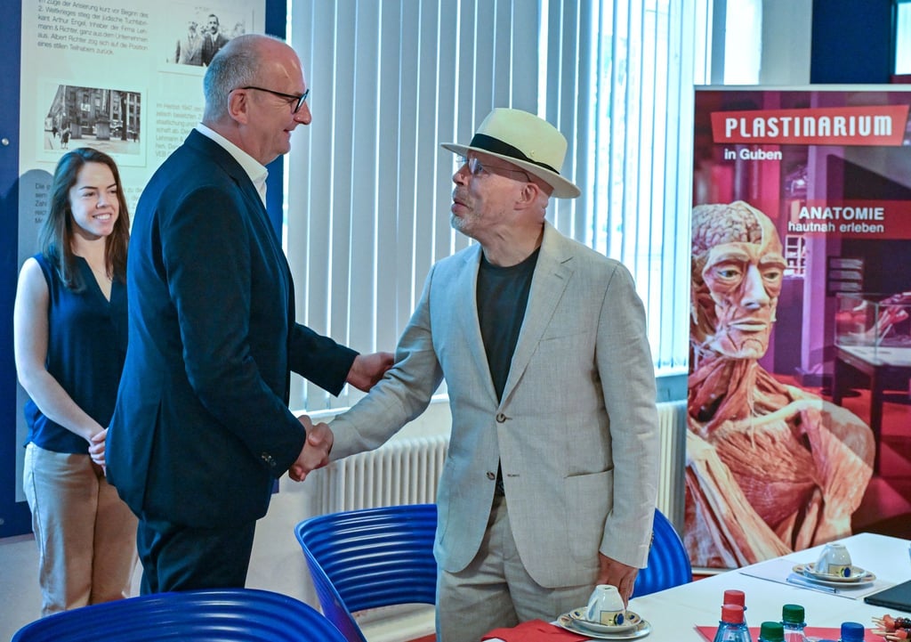 Dietmar Woidke (l, SPD), Ministerpräsident von Brandenburg, wird von Gunther von Hagens, Mediziner, Anatom und Unternehmer, bei seinem Besuch in der Gubener Plastinate GmbH begrüßt.