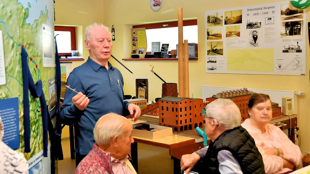 Gerhard Hüttig erzählt die Geschichte des Bergbaus in der Region. Rechts neben ihm das von ihm gebaute Modell der Brikettfabrik