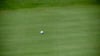 Ein Golfball liegt wenige Zentimeter vor dem Loch.