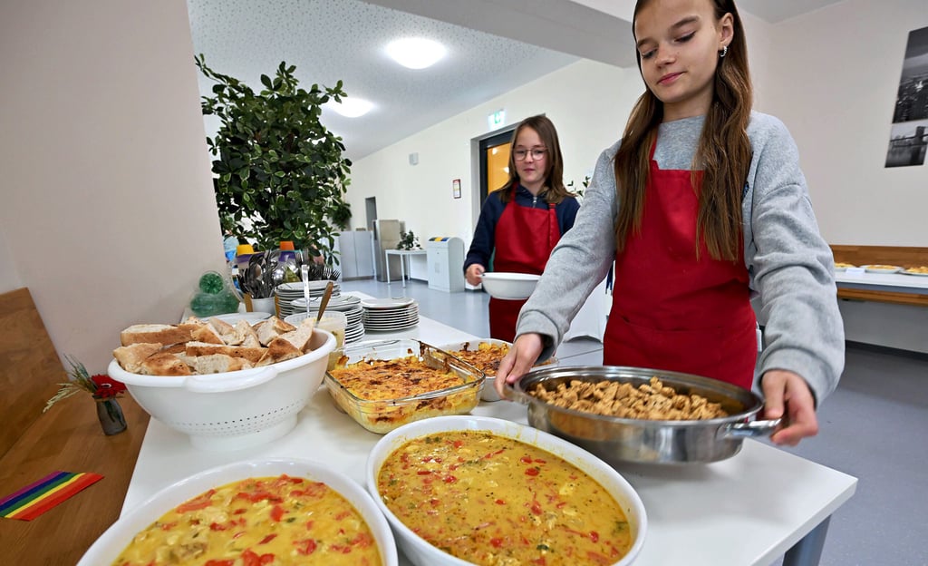 Anna und Amy decken ein. Gemeinsam mit ihren Klassenkameraden haben sie griechische Speisen zubereitet.