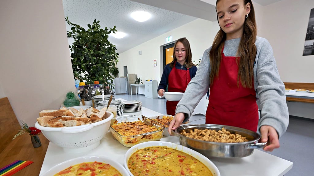 Anna und Amy decken ein. Gemeinsam mit ihren Klassenkameraden haben sie griechische Speisen zubereitet.