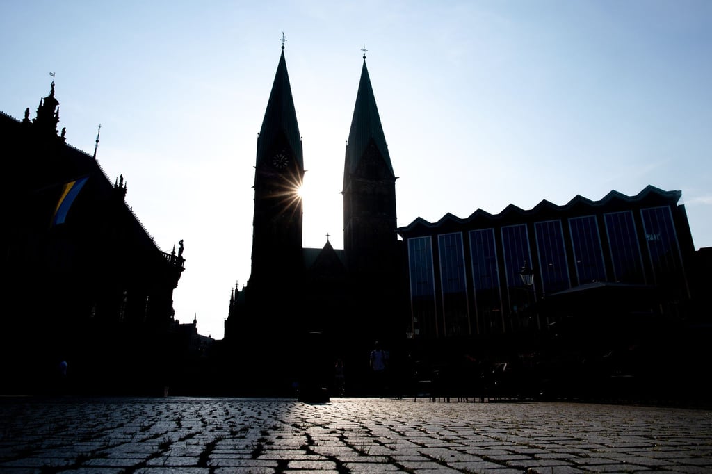 Die Sonne scheint hinter den Türmen des Sankt-Petri-Doms am Bremer Marktplatz.