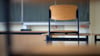 Ein Stuhl steht in einem Klassenzimmer einer Regelschule auf einem Tisch.
