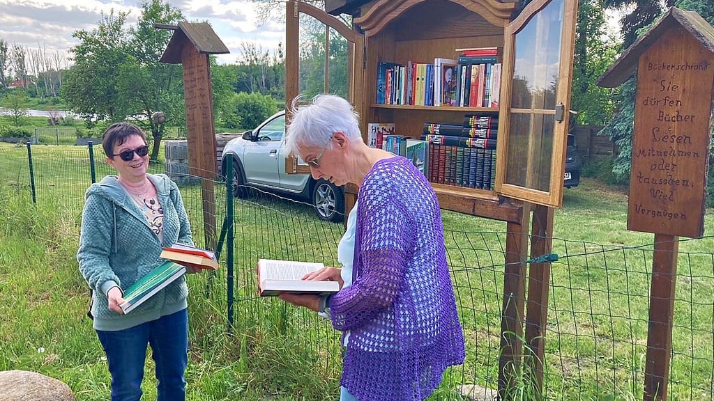 Monika Müller (li.) und Erika Schilling treffen sich am Bücherschrank.