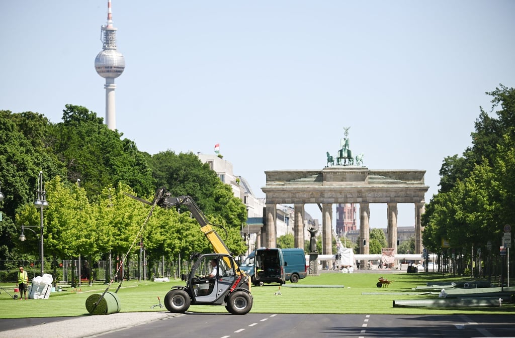 Rollrasen wird auf der Straße des 17. Juni vor dem Brandenburger Tor verlegt.