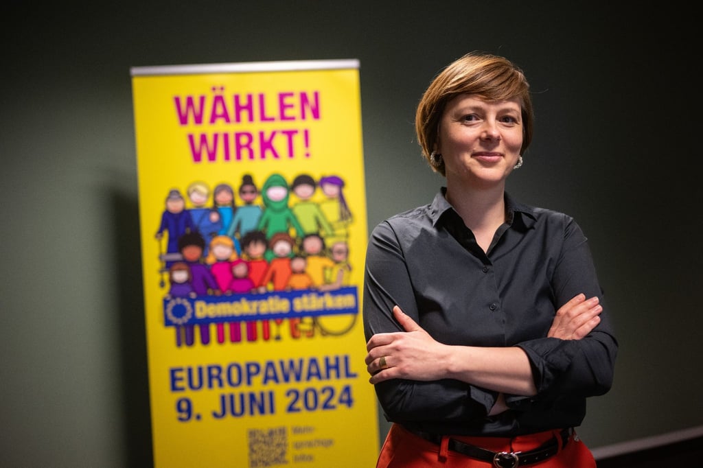 Katarina Niewiedzial, Beauftragte für, Migration der Stadt Berlin, steht vor einem Plakat der Kampagne zur Europawahl 2024.