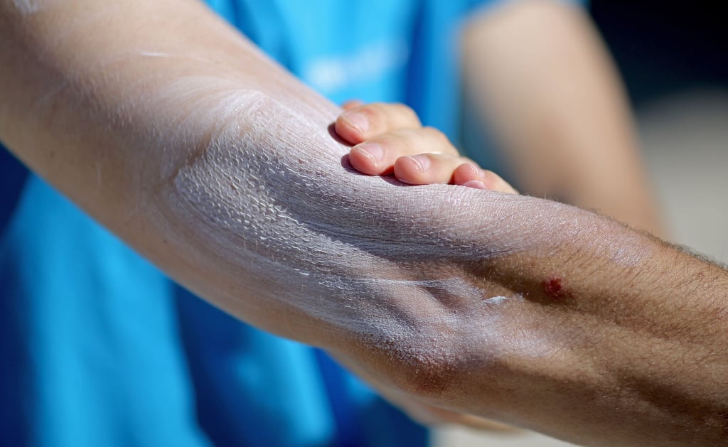 Ein Mann verreibt Sonnencreme auf seinem Arm. Einer aktuellen Umfrage zufolge nutzt gut ein Drittel aller Befragten im Frühjahr und Sommer normalerweise kein Sonnenschutzmittel.