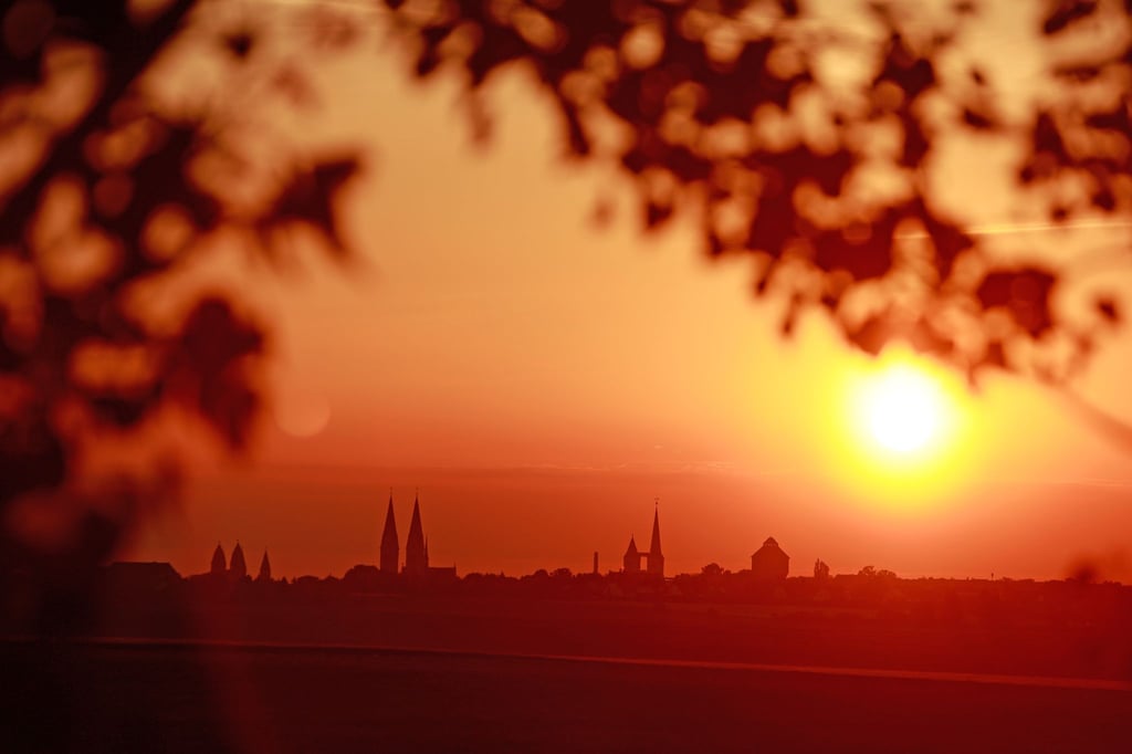 Die Skyline der Stadt Halberstadt mit dem Halberstädter Dom (l.) und der Martinikirche stehen im Licht der aufgehenden Sonne.