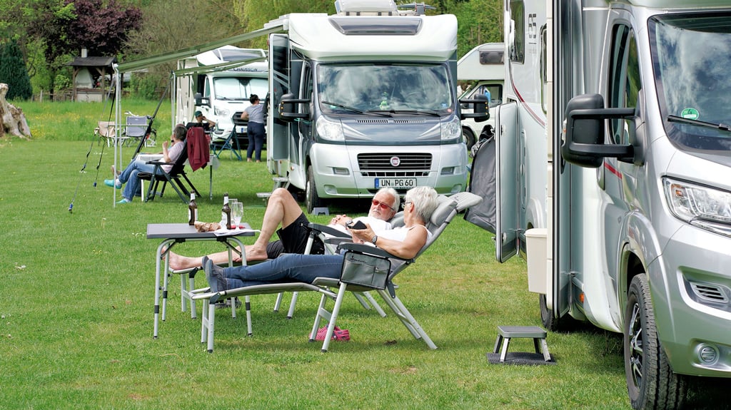 Camper liegen vor ihrem Wohnmobil in der Sonne. Der Altmarkkreis hat die vergleichsweise höchste Dichte an zugelassenen Campern Sachsen-Anhalts.