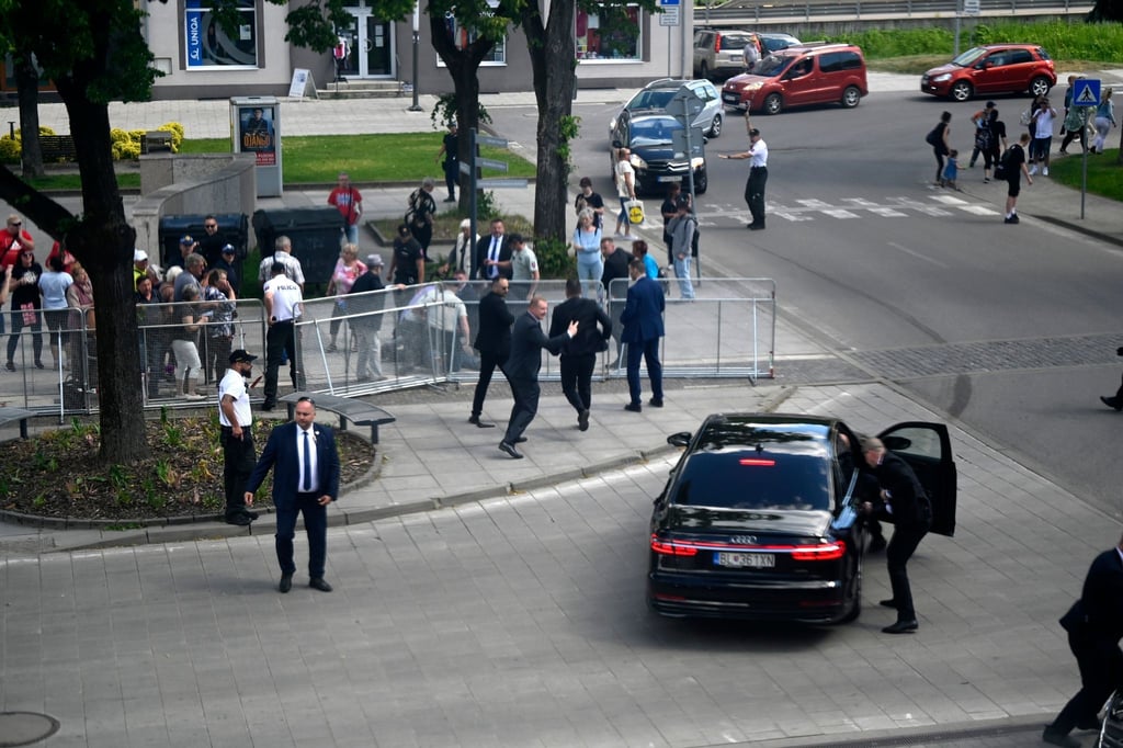 Leibwächter bringen den slowakischen Ministerpräsidenten Robert Fico in einem Auto vom Ort des Geschehens in Sicherheit.