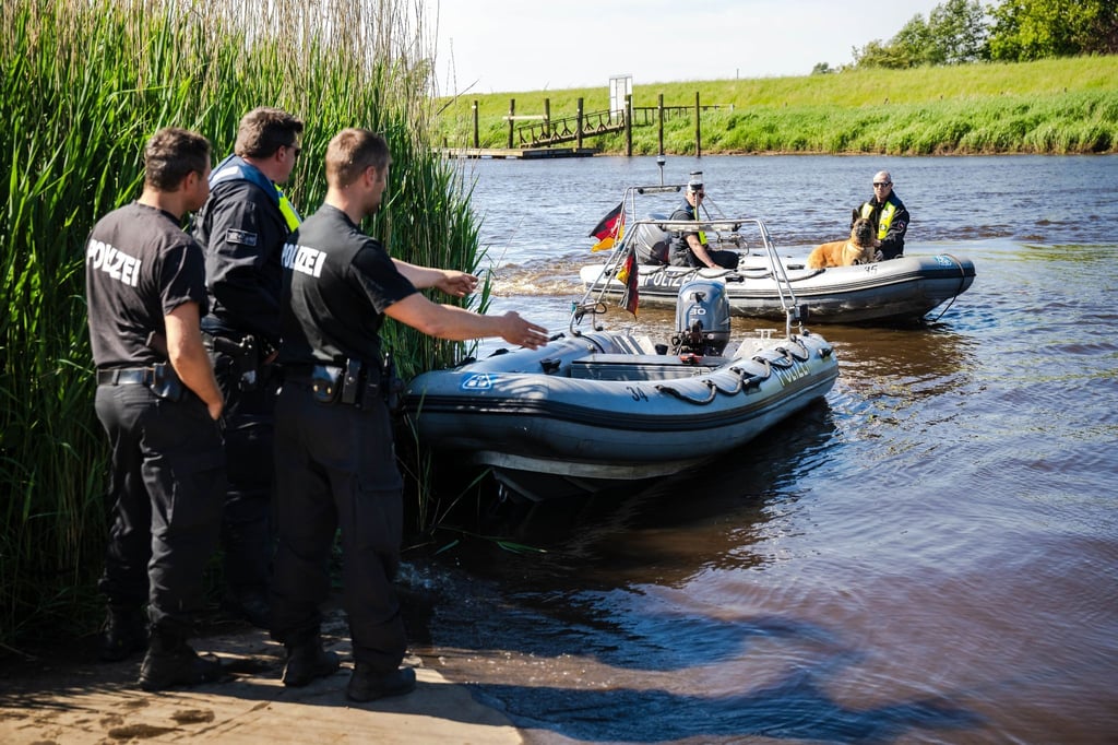 Einsatzkräfte der Polizei fahren bei der Suche nach dem vermissten Arian mit Spürhunden auf Schlauchbooten über die Oste.