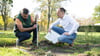 Michael Methner (l), Gartenmeister, und Claudius Wecke, Leiter Bereich Gärten, hocken im Park Großer Garten auf der Freifläche der künftigen Baumschule.
