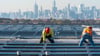 Elektriker installieren im New Yorker Stadtteil Queens Solarpaneele. Die US-Regierung hebt Zoll-Ausnahmen für bestimmte Solar-Importe auf.