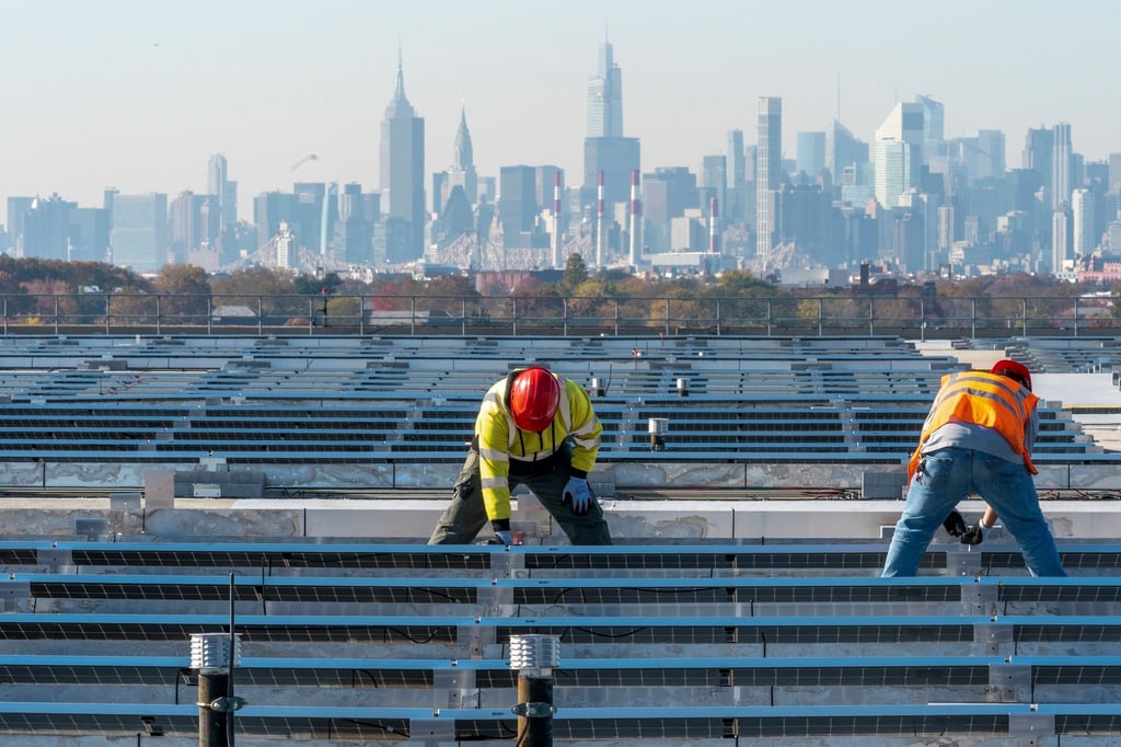 Elektriker installieren im New Yorker Stadtteil Queens Solarpaneele. Die US-Regierung hebt Zoll-Ausnahmen für bestimmte Solar-Importe auf.