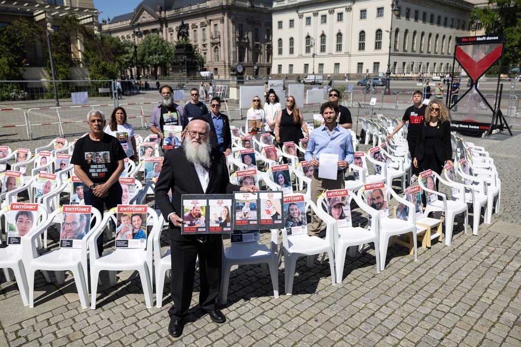 Angehöre von Geiseln und Teilnehmer der Veranstaltung stehen auf dem Beblplatz. Der Bebelplatz soll für einige Wochen symbolisch zum „Platz der Hamas-Geiseln“ werden. Es wurden auch 132 leere Stühle aufgestellt.