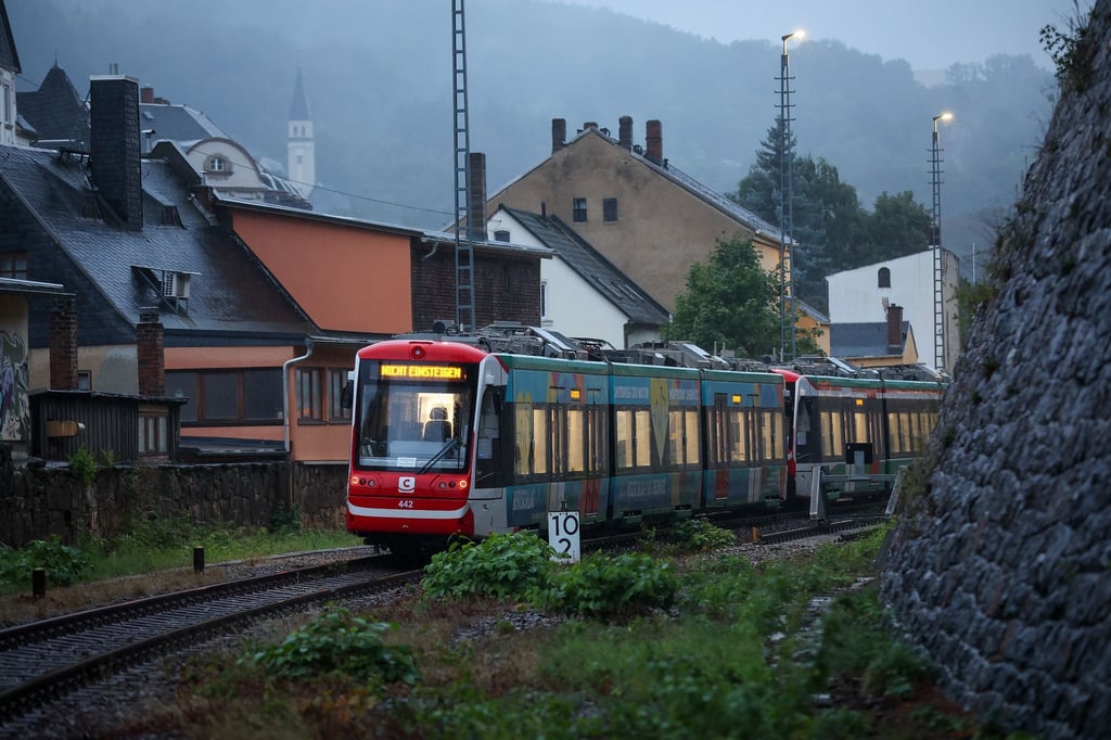 Eine City-Bahn nach Chemnitz steht bei Regen und einsetzender Dunkelheit im Bahnhof.