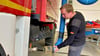 Oliver Kirchner verbindet den Abgasschlauch mit dem Dekontaminationsfahrzeug der Coswiger Feuerwehr.