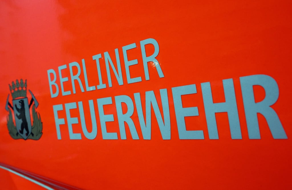 Der Schriftzug „Berliner Feuerwehr“ und das Wappen Berliner Feuerwehr stehen auf der Tür eines Feuerwehrfahrzeuges.