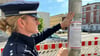 Polizeisprecherin Tracy Hering beim Anbringen eines der Plakate mit Zeugenaufruf in Magdeburg-Fermersleben. Hier hatte ein Mann eine Frau niedergeschossen. 