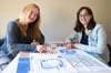 Die Studentinnen Ann-Katrin Gerstung (r.) und Anna Tappe mit ihrem Prototypen des Spiels „Explore“. 