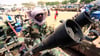 Ein Milizionär sitzt neben militärischer Ausrüstung, die angeblich während eines Gefechts im umkämpften Gebiet in Süd-Darfur erbeutet wurde.