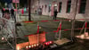 Brennende Kerzen stehen vor Schildern mit der Aufschrift „Stop Antisemitismus“ an dem abgesperrten Bürgersteig.