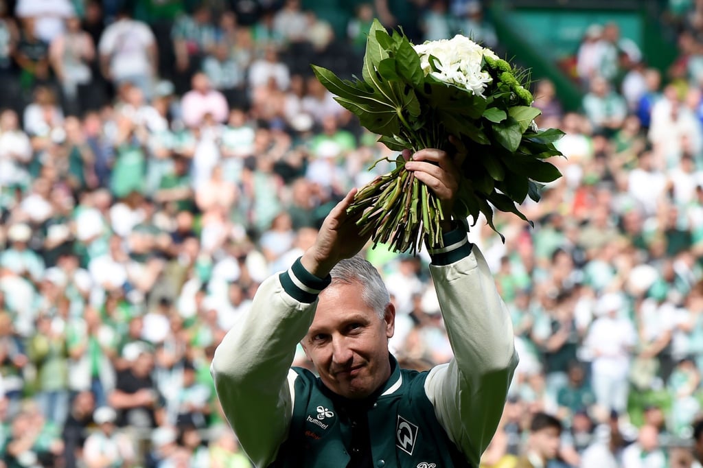 Frank Baumann, Geschäftsführer Fußball beim SV Werder Bremen, wird mit einem Blumenstrauß verabschiedet.