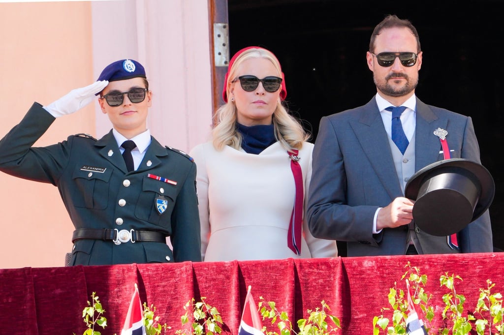 Kronprinzessin Mette-Marit (M), Kronprinz Haakon (r) und Prinzessin Ingrid Alexandra begrüßen den Kinderzug vom Schlossbalkon.