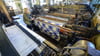 Eine Frau bedient einen der zahllosen Webstühle im Textilmuseum in der Tuchfabrik Gebr. Pfau.