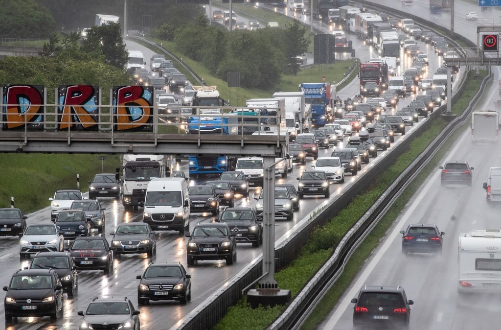 Autos und Lastkraftwagen stauen sich bei Regen auf einer Autobahn.