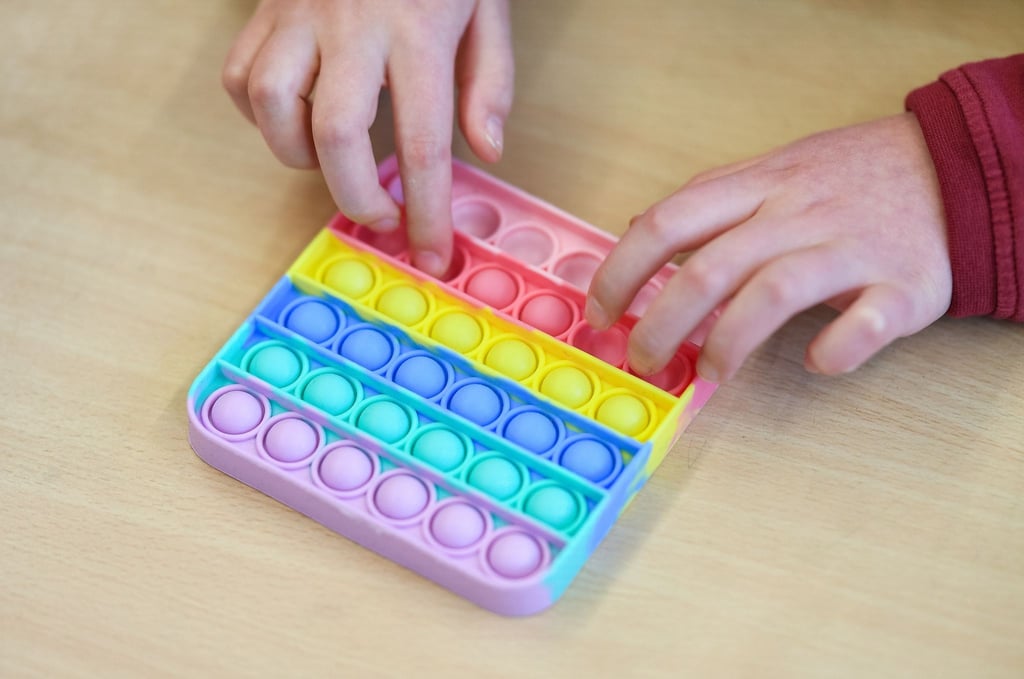 In einem Klassenzimmer einer Grundschule spielt ein Kind mit Pop-Its.