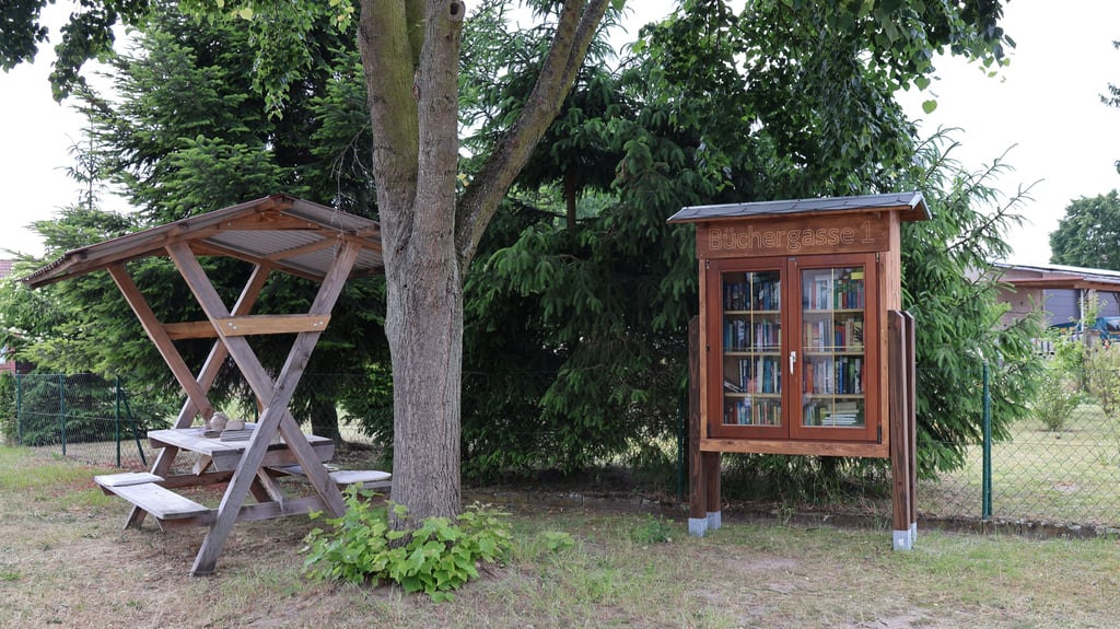 Der öffentliche Bücherschrank in Schönfeld trägt den Namen „Büchergasse 1“. Leute kommen zum Klönen und Lesen.