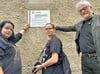 Cindy und Corinna Jänig bringen in Burg mit Stefan Böhme ein Erinnerungsschild an einem ehemaligen Jugendwerkhof-Gebäude an. 