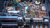 Eine Platine mit elektronischen Bauteilen in einer Musikanlage wird in einer Werkstatt repariert.