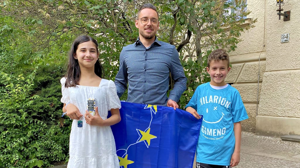 Alina (v. l.), Steven Hebestreit und Amir zeigen die Europaflagge und ihre Mitbringsel aus den Schüleraustauschen in Finnland und Spanien.