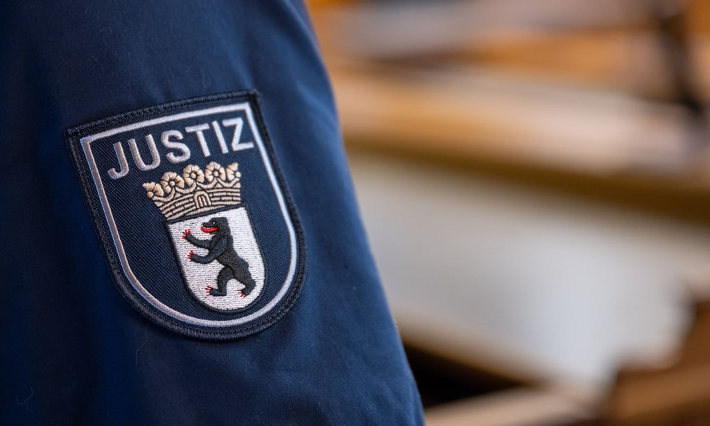 Ein Abzeichen mit dem Wort „Justiz“ und dem Landeswappen von Berlin ist an der Uniform eines Justizvollzugsbeamten im Kriminalgericht Moabit angebracht.