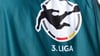 Ein Mitarbeiter der Fernsehproduktion trägt ein Leibchen mit dem Logo der 3. Liga.