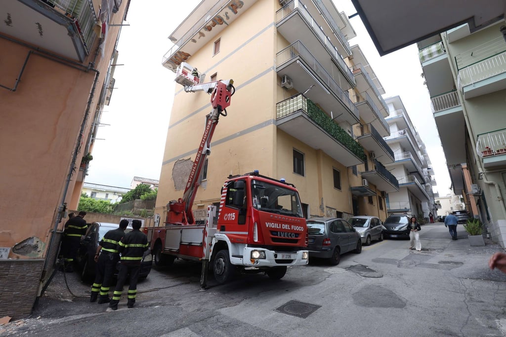 Von einem Hubwagen aus inspiziert ein Feuerwehrmann Schäden an einem Gebäude in Pozzuoli.