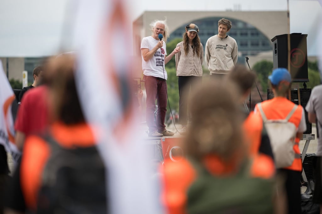 Die Angeklagten Edmund Schultz (hinten, l-r), Mirjam Herrmann, und Henning Jeschke stehen bei einer Demonstration auf der Bühne.